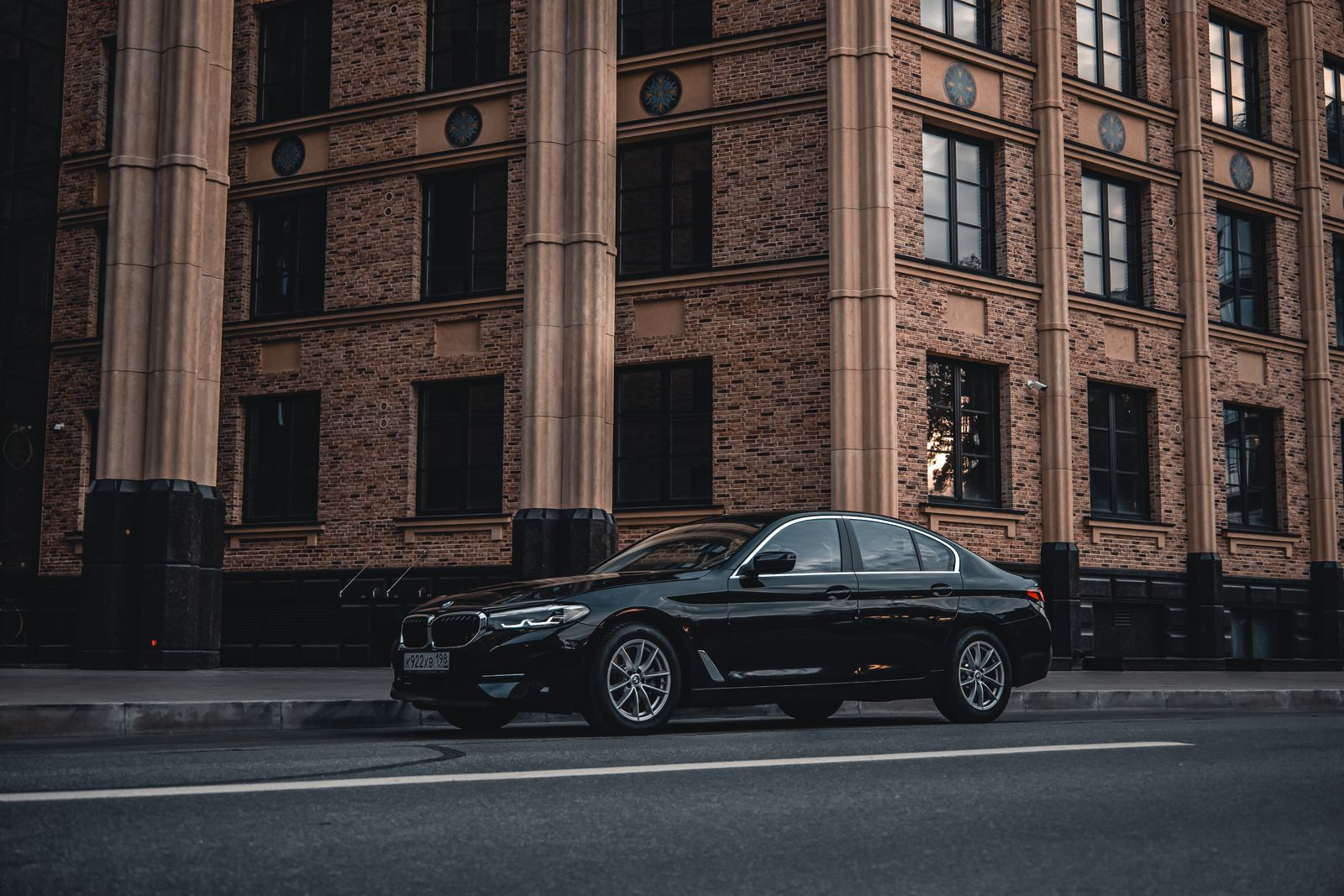 Elegant luxury car parked in front of a historic brick building, exuding style and sophistication.